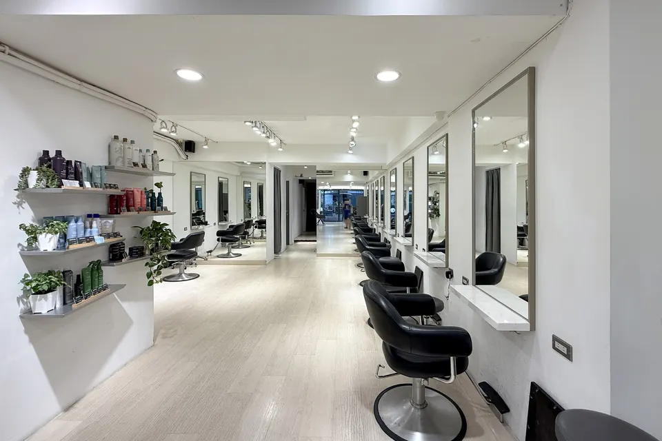 沙龍走道旁的 Aveda 髮品層架與一整排造型座椅